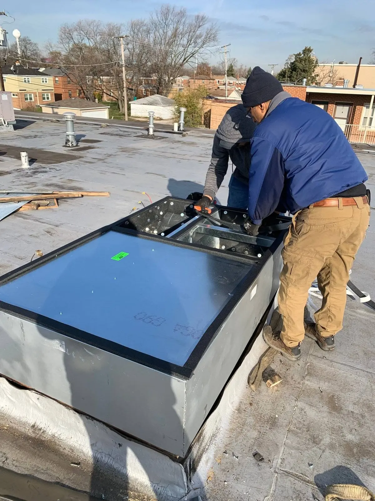 Technicians working on rooftop HVAC equipment
