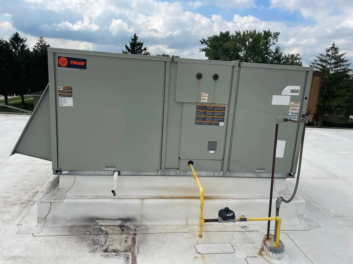 Packaged rooftop heating and cooling unit on a commercial roof